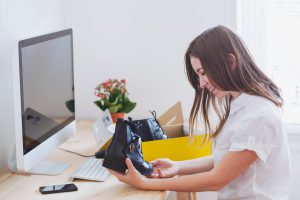 shopping online concept, happy woman opens box with new shoes, ordered by internet
